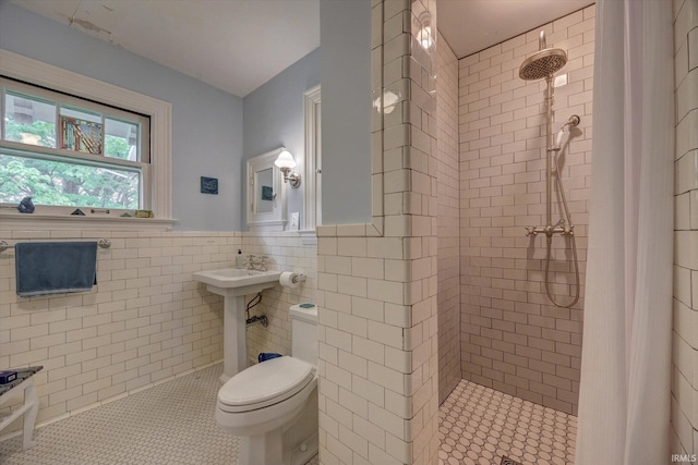 104 W Main St, Worthington, IN 47471 - full bathroom featuring tile walls, toilet, a tile shower, tile patterned floors, and a wainscoted wall