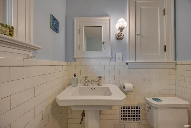 104 W Main St, Worthington, IN 47471 - bathroom featuring tile walls, toilet, visible vents, and a wainscoted wall