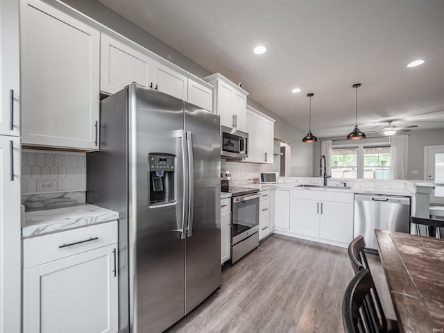 kitchen with recessed lighting, white cabinetry, stainless steel appliances, and a sink