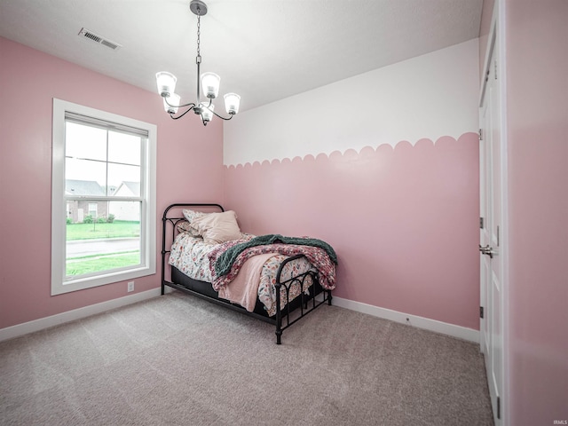 carpeted bedroom featuring a notable chandelier, baseboards, and visible vents