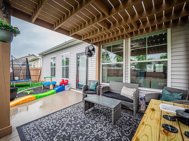 view of patio with an outdoor living space, a trampoline, and fence