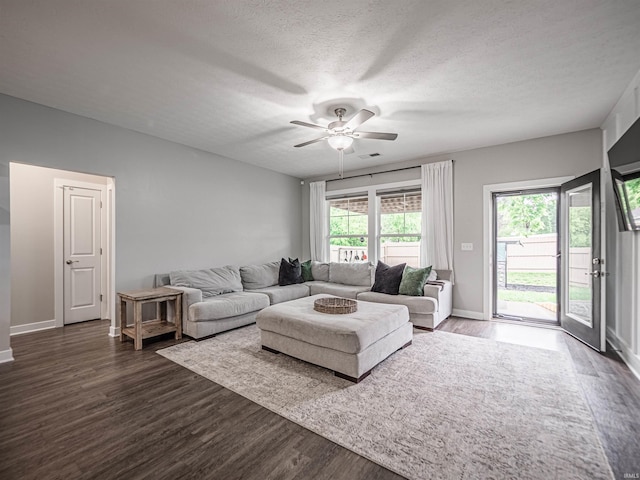 living room featuring a ceiling fan, baseboards, plenty of natural light, and dark wood-type flooring