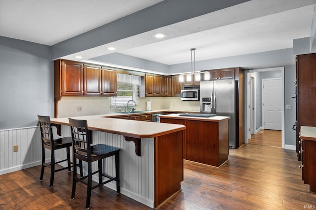 5259 E Willow Ct, Monticello, IN 47960 - kitchen featuring a peninsula, appliances with stainless steel finishes, dark wood-style flooring, and a sink