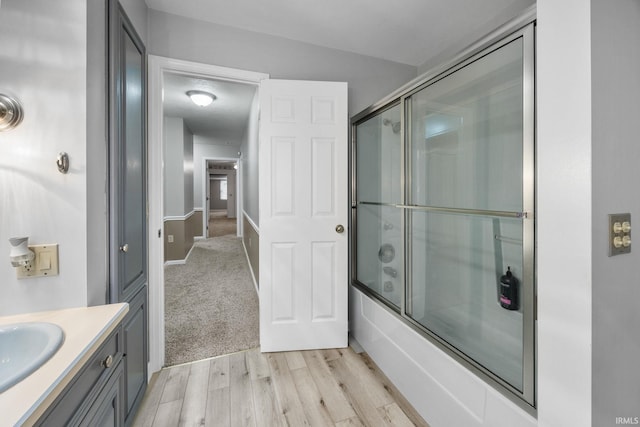 5259 E Willow Ct, Monticello, IN 47960 - bathroom featuring wood finished floors, vanity, and shower / bath combination with glass door