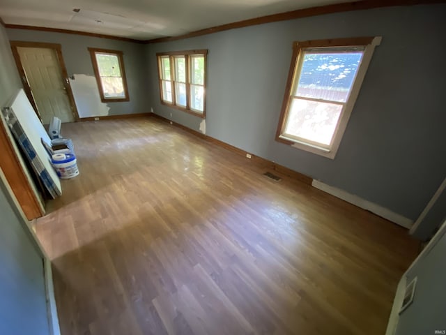 1514 Van Buren St, South Bend, IN 46628 - unfurnished living room featuring crown molding, light wood-type flooring, visible vents, and baseboards