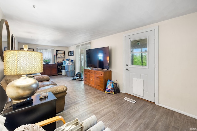 living room with visible vents, wood finished floors, and baseboards