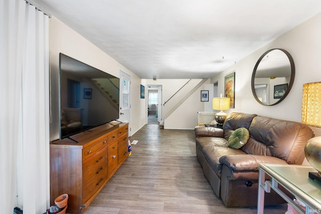 living room with baseboards, stairs, and wood finished floors