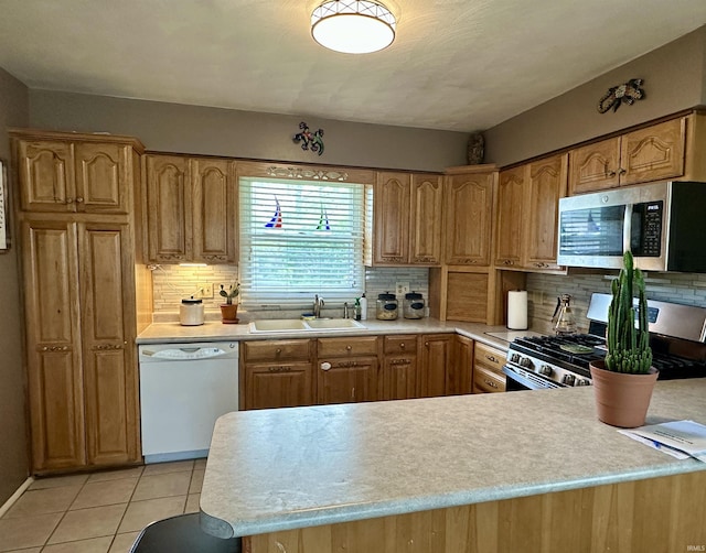 kitchen with a sink, light countertops, and appliances with stainless steel finishes