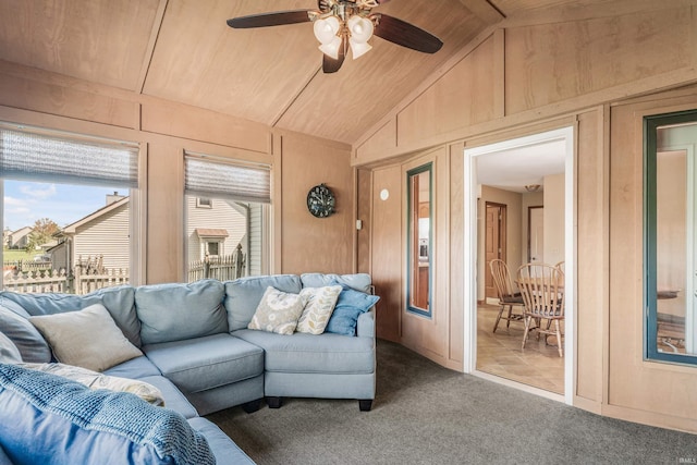 carpeted living area featuring lofted ceiling, wood ceiling, a ceiling fan, and wooden walls