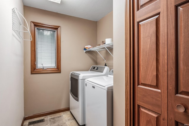 clothes washing area featuring laundry area, baseboards, separate washer and dryer, and visible vents