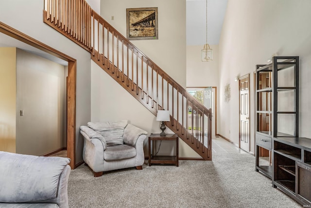 interior space with baseboards, a towering ceiling, and carpet floors