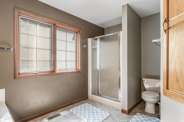 full bath with toilet, visible vents, baseboards, a shower stall, and tile patterned flooring