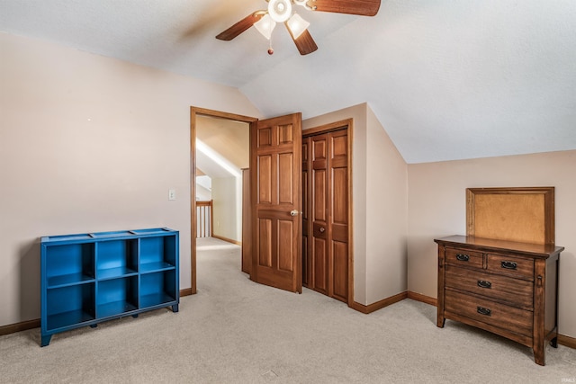 additional living space with a ceiling fan, baseboards, light colored carpet, and vaulted ceiling