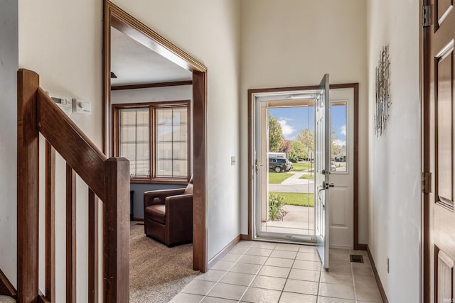 doorway to outside with crown molding, stairs, baseboards, and light tile patterned floors