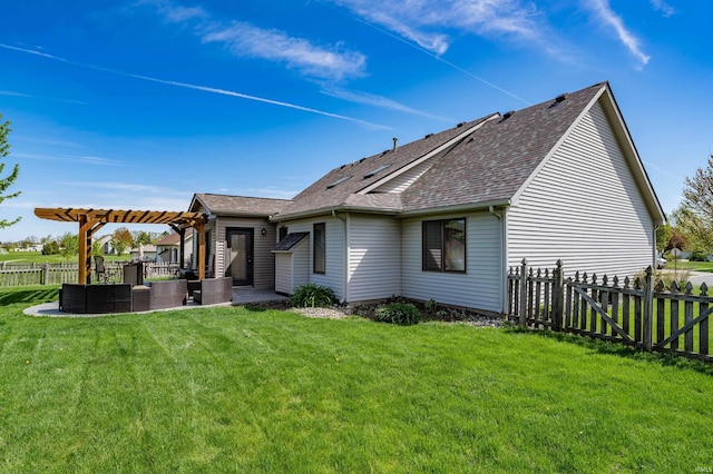 back of house with a shingled roof, a pergola, a lawn, and a fenced backyard