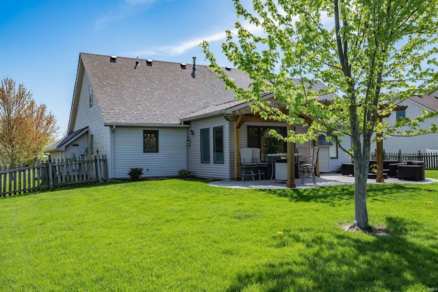 rear view of property with a shingled roof, a patio area, fence, and a lawn