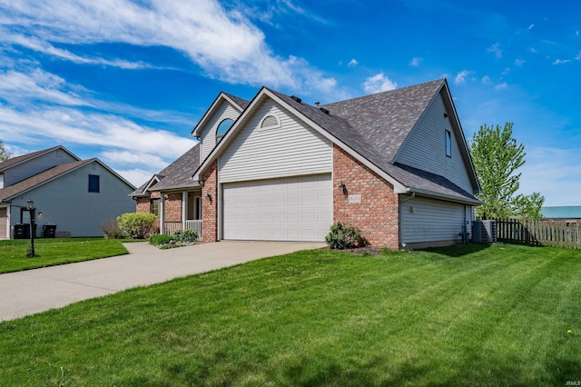 traditional-style home featuring an attached garage, fence, a front yard, brick siding, and driveway