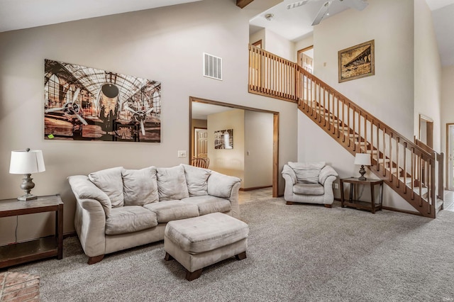 living area with stairs, high vaulted ceiling, visible vents, carpet floors, and a ceiling fan