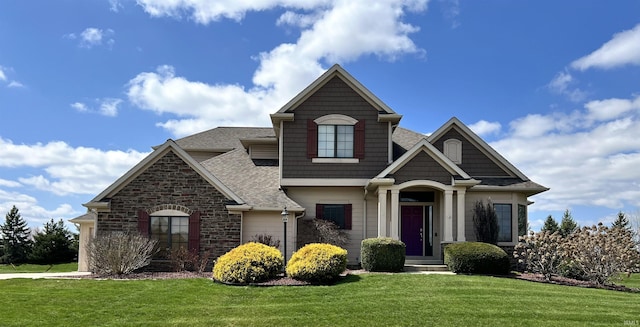 craftsman house with roof with shingles and a front lawn