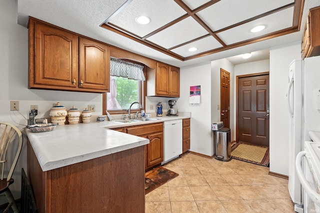 kitchen featuring a peninsula, brown cabinets, a sink, dishwasher, and recessed lighting