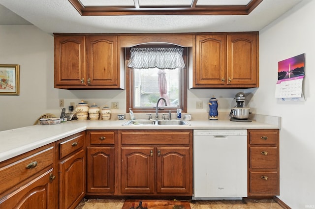 kitchen with a sink, light countertops, white dishwasher, and brown cabinets