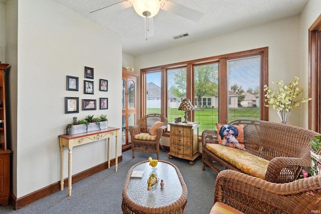 interior space featuring carpet, a textured ceiling, visible vents, baseboards, and ceiling fan