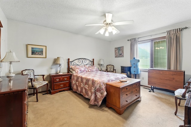 bedroom with light colored carpet, a textured ceiling, and ceiling fan