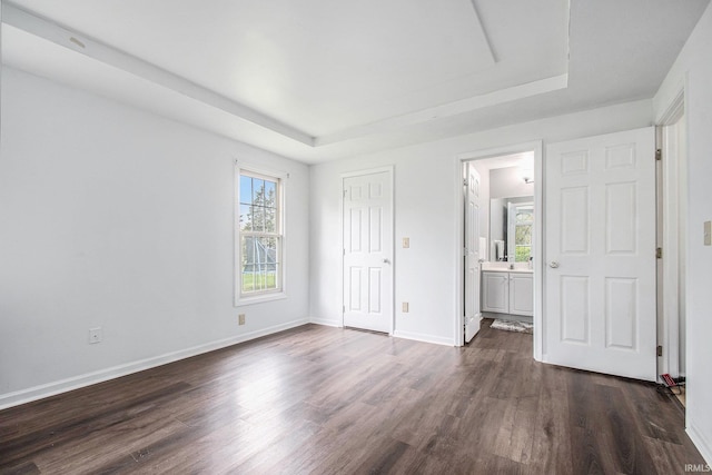 21521 Cheri Ln, Bristol, IN 46507 - unfurnished bedroom with dark wood-type flooring, baseboards, and a raised ceiling