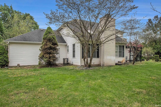 21521 Cheri Ln, Bristol, IN 46507 - exterior space with central AC unit, roof with shingles, a chimney, and a lawn