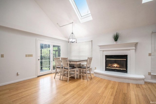 21521 Cheri Ln, Bristol, IN 46507 - dining room featuring light wood finished floors, high vaulted ceiling, a skylight, a brick fireplace, and a chandelier