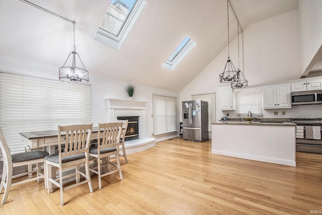 21521 Cheri Ln, Bristol, IN 46507 - kitchen featuring stainless steel appliances, an inviting chandelier, high vaulted ceiling, and a skylight