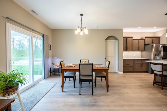 dining area with a chandelier, plenty of natural light, visible vents, and light wood-style floors