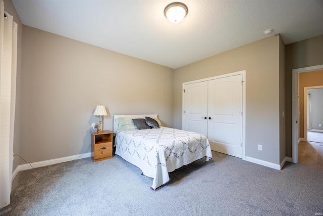 carpeted bedroom featuring baseboards and a closet