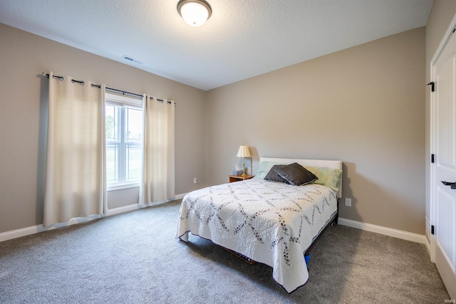 bedroom featuring a textured ceiling, carpet, baseboards, and visible vents