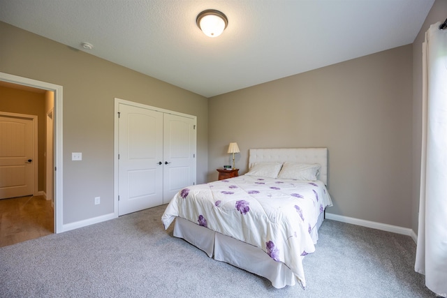 carpeted bedroom with baseboards and a closet