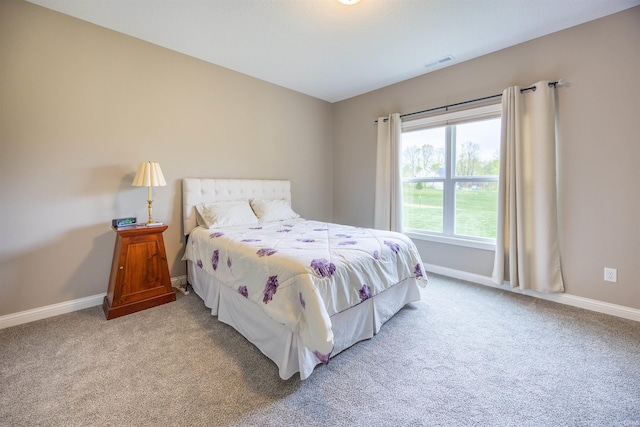carpeted bedroom with visible vents and baseboards