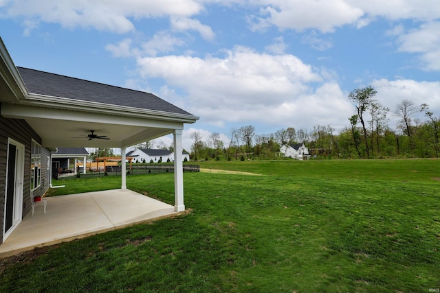 view of yard featuring a ceiling fan and a patio area