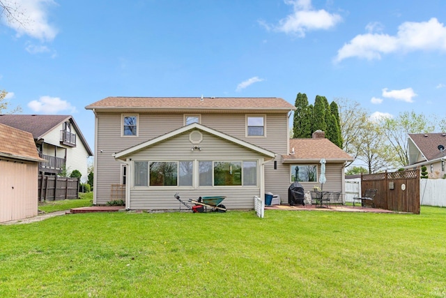 back of house featuring a lawn, a patio area, fence, and a storage unit