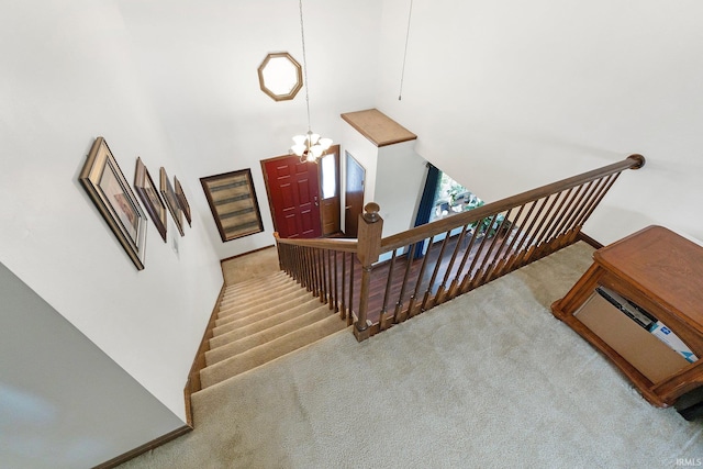 staircase with a chandelier, carpet, and a towering ceiling