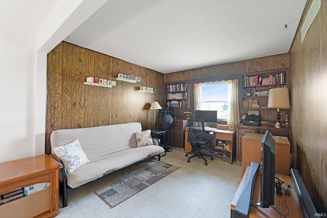 office space featuring wood walls, carpet, and a textured ceiling