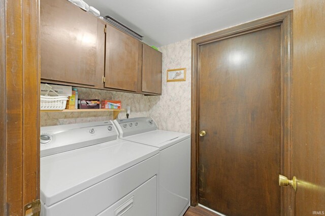laundry room with washer and dryer, wallpapered walls, and cabinet space