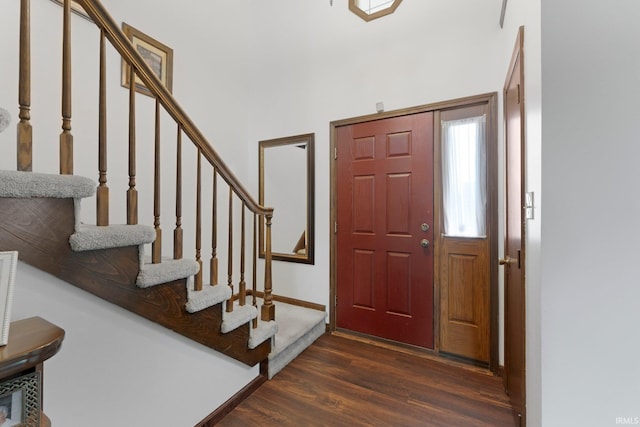 foyer featuring dark wood-style flooring, stairs, and baseboards