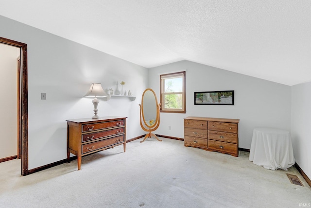 bedroom with vaulted ceiling, baseboards, visible vents, and light carpet