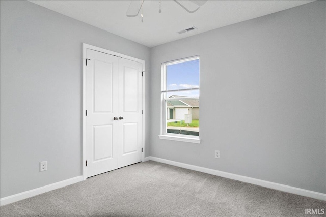 unfurnished bedroom featuring a closet, visible vents, baseboards, and carpet floors