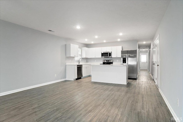 kitchen with baseboards, stainless steel appliances, dark wood finished floors, and visible vents