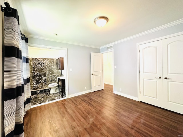 bedroom featuring ornamental molding, baseboards, visible vents, and wood finished floors