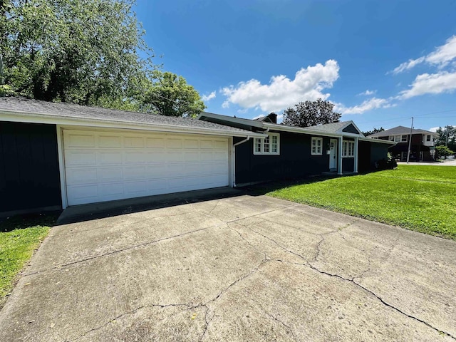 ranch-style home with concrete driveway, a front lawn, and an attached garage