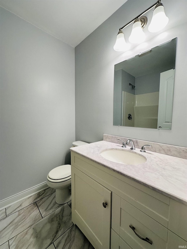 bathroom with baseboards, marble finish floor, toilet, vanity, and a shower