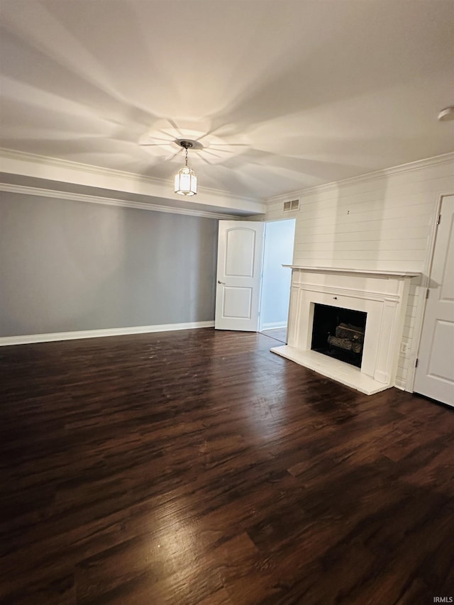 unfurnished living room with a fireplace with raised hearth, visible vents, crown molding, dark wood-style flooring, and baseboards