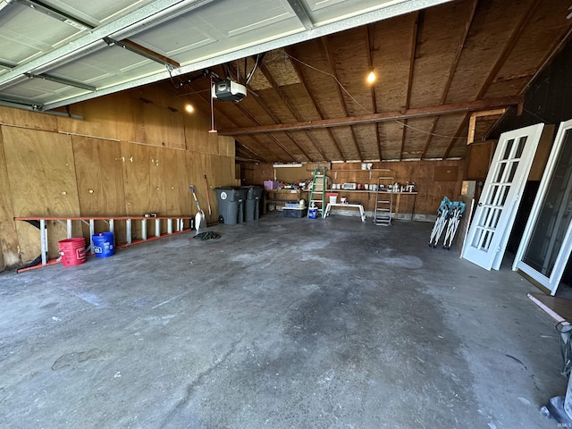 garage with wooden walls and a garage door opener